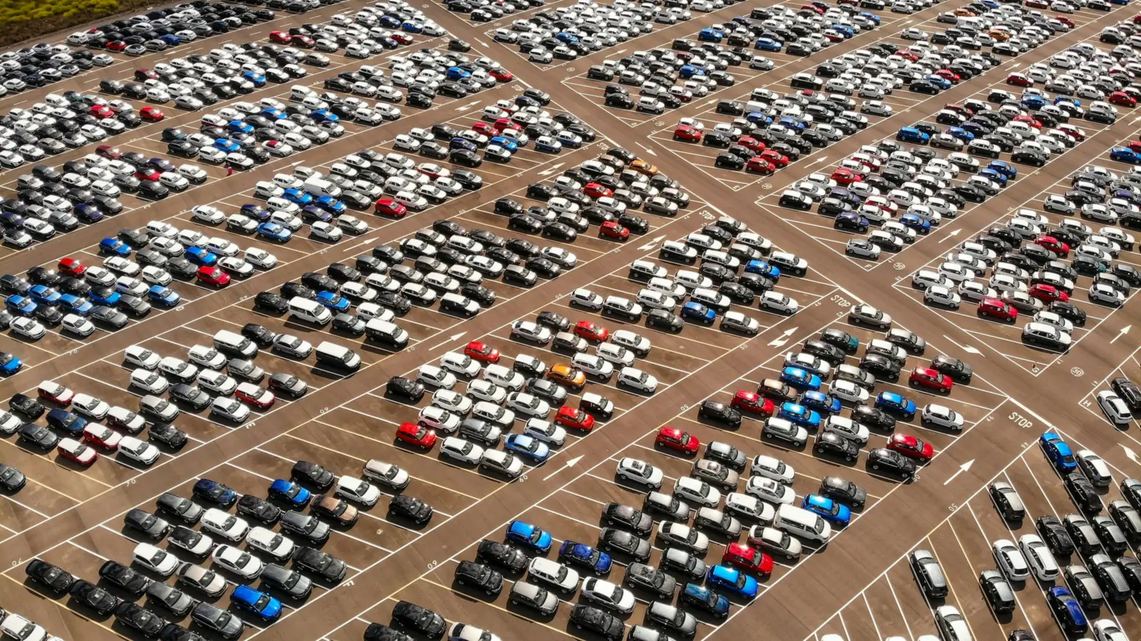 Aerial view of a large storage lot with hundreds of vehicles parked in rows