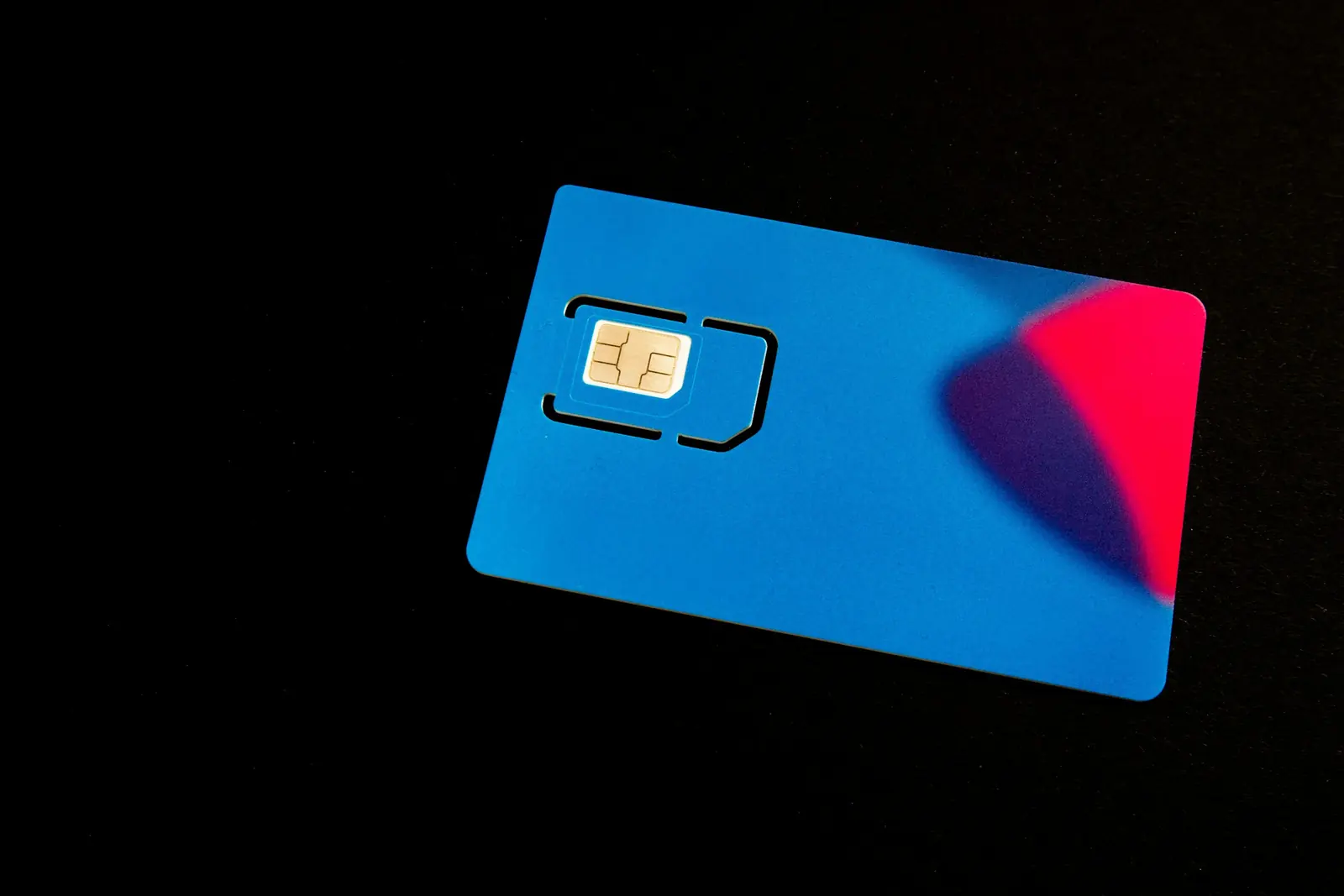 Blank blue plastic card with an embedded electronic chip on a black background
